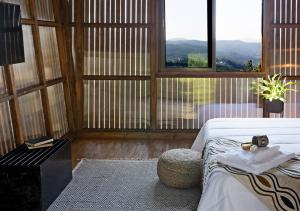 a room with a bed and a table and windows at Cimo da Vinha - Nature Spot in Castelo de Paiva +16 photos