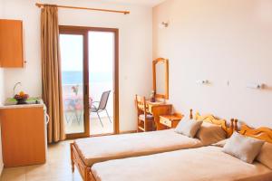 1 dormitorio con 2 camas y balcón con vistas al océano en Hotel Krinos, en Karpathos