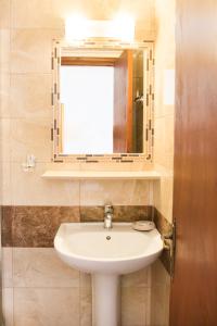 ein Bad mit einem Waschbecken und einem Spiegel in der Unterkunft Hotel Krinos in Karpathos