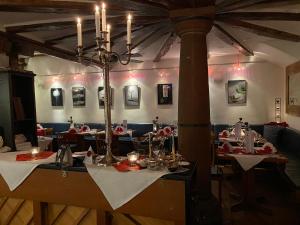 a dining room with tables and chairs and a chandelier at Marktplatzhotel - Restaurant Tafelspitz in Weinheim
