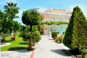 a building with trees in front of a garden at VILLA BORA in Leptokarya