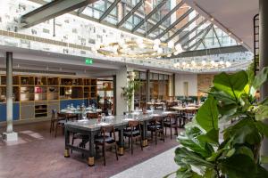 a restaurant with tables and chairs and a glass ceiling at Telegraph Hotel - Coventry in Coventry