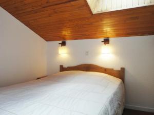 メリベルにあるAppartement Méribel, 2 pièces, 6 personnes - FR-1-182-107の木製の天井のベッドルーム1室(白いベッド1台付)