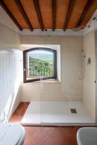 baño con ducha y ventana en Hotel Vecchia Oliviera en Montalcino