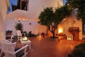 une cour avec un arbre, une table et des chaises dans l'établissement Philoxenia Guest House, à Skopelos