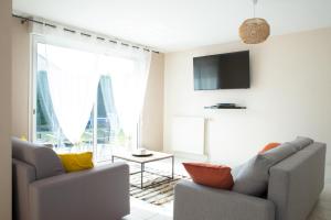 een woonkamer met 2 stoelen en een televisie bij Villa avec Jardin 600m² Netflix proche Toulouse in Colomiers