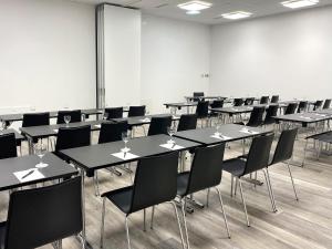 a large room with tables and chairs in it at DORMERO Hotel Deggendorf in Deggendorf