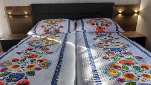 uma cama com duas almofadas com flores em Agrodomki-OKEJ Dom Belweder em Gardna Wielka