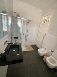 a bathroom with a black sink and a toilet at Casa Branca in Ericeira