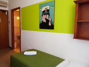 a green room with a bed and a painting on the wall at Casa Accademia in Venice