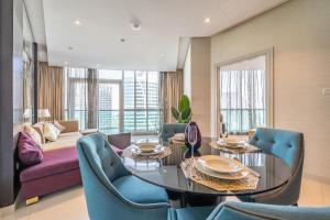 a living room with a couch and a table and chairs at Primestay - Luxurious Breathtaking 1BR in Downtown in Dubai