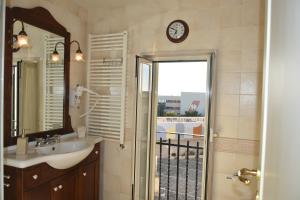 ein Badezimmer mit einem Waschbecken und einer Uhr an der Wand in der Unterkunft Domida Apartment in Bari + 16 Fotos
