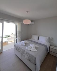 1 dormitorio con cama y ventana grande en Aria, Maisonette in Glyfada Beach, en Glyfada