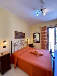 a bedroom with a large bed with a red bedspread at Baglio Cusenza Rooms in San Vito lo Capo