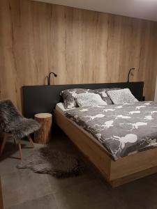 um quarto com uma cama e uma parede de madeira em Apartmán Pod Hochfichtem em Nová Pec