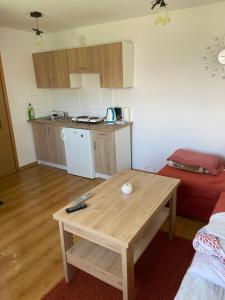a living room with a table and a kitchen at Domek wakacyjny in Charzykowy