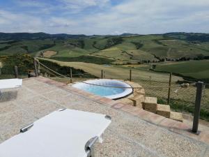 a pool on a patio with a view of the hills at Agriturismo Collomici in Celle sul Rigo