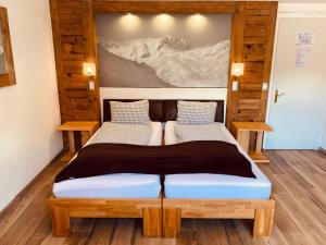 two beds in a room with a painting on the wall at Mountain Lodge Sedrun in Sedrun