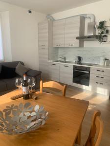 uma cozinha com uma mesa de madeira e uma garrafa de vinho em In centro Ca' Leandro Vista lago em Lierna