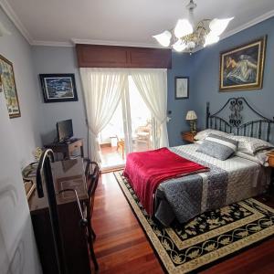 um quarto com uma cama com um cobertor vermelho em O Seixo 2 em Mugardos