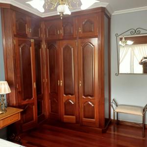 a wooden cabinet in a room with a table and a lamp at O Seixo 2 in Mugardos