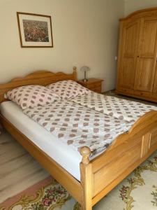 1 dormitorio con cama de madera y tocador de madera en W Ciemno en Ciemno