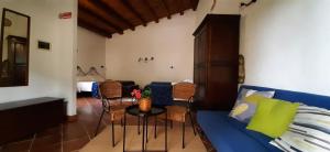 a living room with a blue couch and a table at Casale Ginisara in Castellammare del Golfo