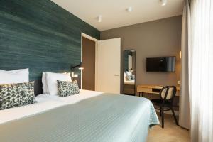 1 dormitorio con 1 cama y escritorio con TV en BizStay Maurits, en La Haya