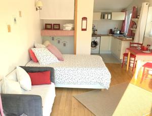 een kleine kamer met een bed en een bank bij Cottage Blagnac in Beauzelle