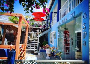 a blue building with a staircase and an umbrella at Casa Royal Palm Inn in San Andrés