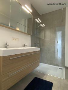 a bathroom with a sink and a shower at Residentie Duinenzucht - Appartement Laure I Studio Lynne in Bredene