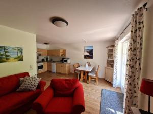 a living room with a red couch and a table at Zingst Achtern Diek 12d Elly in Zingst