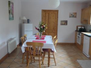 a kitchen with a table with a vase of flowers on it at Glebe cottage in Kinvara