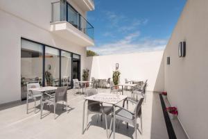 patio ze stołami i krzesłami w budynku w obiekcie Hotel Costa da Morte w mieście Fisterra