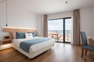 sypialnia z łóżkiem i widokiem na ocean w obiekcie Hotel Costa da Morte w mieście Fisterra