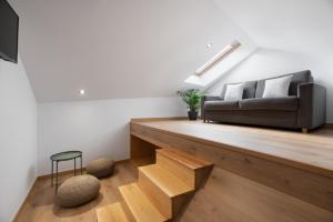 salon z czarną kanapą i drewnianymi schodami w obiekcie Hotel Costa da Morte w mieście Fisterra