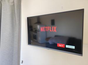 einen Fernseher an der Wand mit den Worten Netflix in der Unterkunft Panoramic sea view apartment in Polis-Latchi in Polis Chrysochous