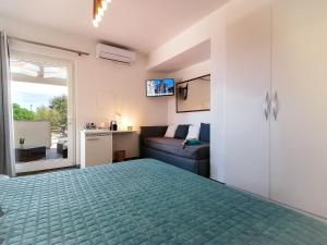 サンタ・テレーザ・ガッルーラにあるB&B La Torre Eliteのベッドルーム1室(ベッド1台、ソファ、窓付)