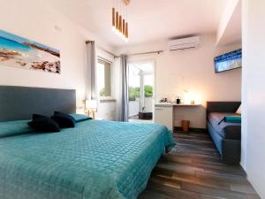 ein Schlafzimmer mit einem grünen Bett und einem Sofa in der Unterkunft B&B La Torre Elite in Santa Teresa Gallura