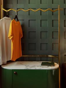 an orange shirt on a hanger in a room at The Hoxton, Rome in Rome
