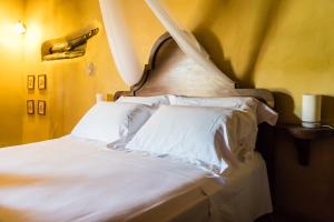 Borgo TicinoにあるRelais Dei Cesariのベッド(白いシーツ、枕付)
