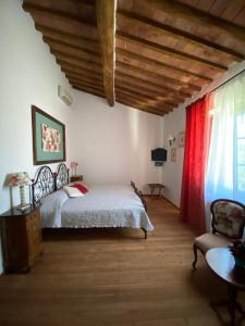 a bedroom with a bed and a red curtain at Relais Felciaino B&B in Bolgheri