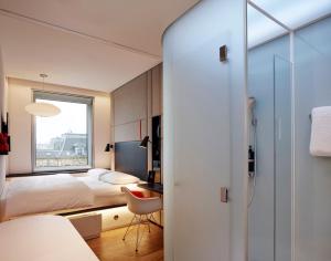 1 dormitorio con cama, escritorio y ventana en citizenM Copenhagen Radhuspladsen en Copenhague