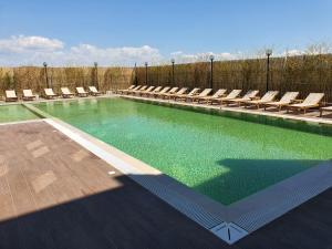 a swimming pool with lounge chairs and a swimming pool at Amber Hotel Albania in Spille