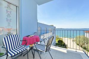 Un balcón con sillas y una mesa con vistas al océano. en Apartment Nadica, en Kožino