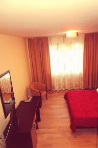 a hotel room with a bed and a television at Hotel Nord in Ploieşti