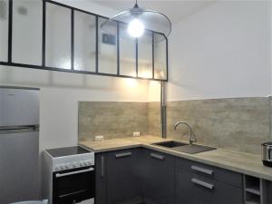 une cuisine avec un évier et une cuisinière dans l'établissement Appartement Triangle d Or plage-gareTGV-Mairie, à Saint-Raphaël 6 autres photos