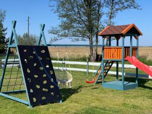 a playground with two swings and a slide at 2bedroom house in Mērsrags