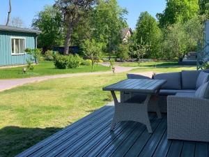 een houten terras met een tafel en een bank bij 2bedroom house in Mērsrags