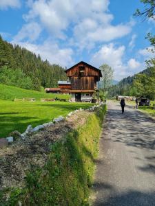 a person walking down a road next to a building at Casa Tiziano e Nila in Santo Stefano di Cadore